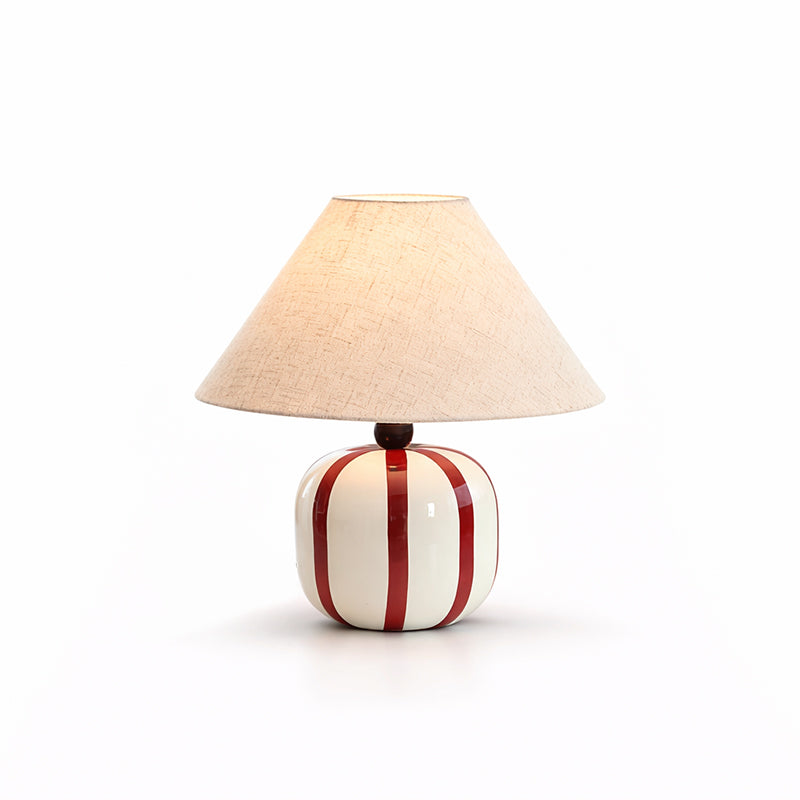 This Clérachic table lamp with red and white stripes, shown lit on a clean white background with a soft shadow.