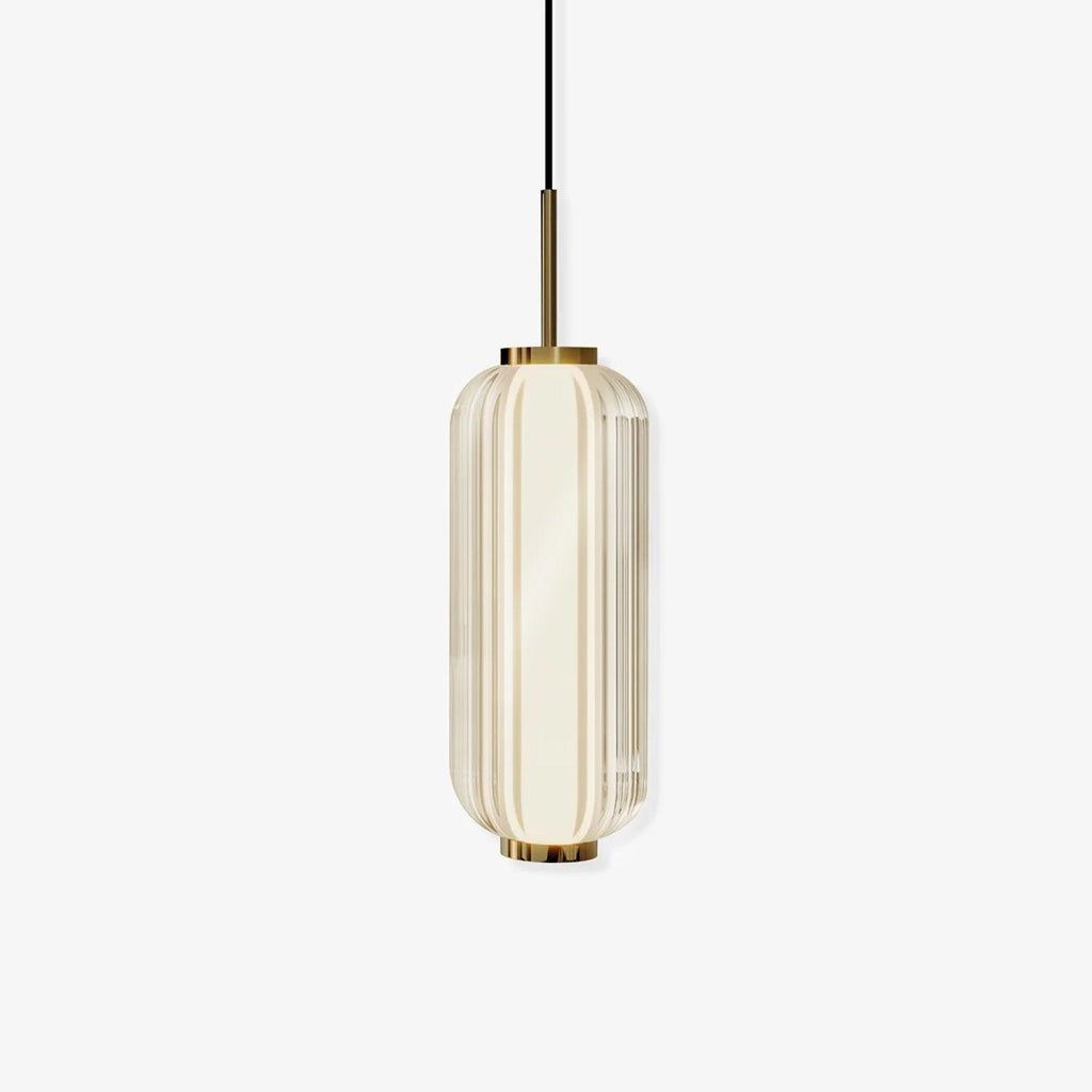 A ribbed glass cylinder pendant with gold fittings, shown lit on a plain off-white backdrop, from Clérachic.