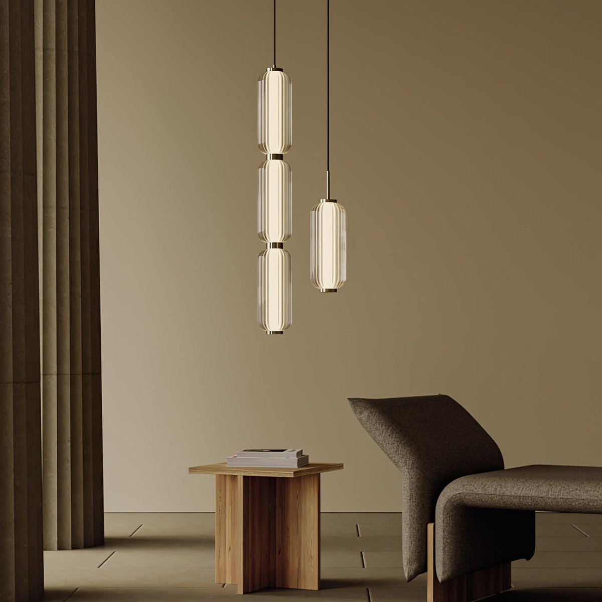 A three-tier and a single ribbed glass Clérachic pendant hang in a warm beige room, beside a low wooden table and a lounge chair.