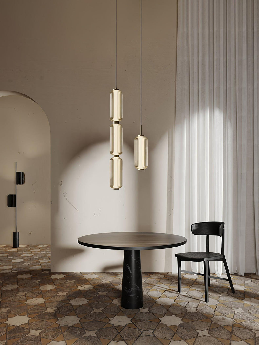 Two Clérachic ribbed glass pendants, a stacked one and a single, hang above a round table and black chair, beside a pale curtain.