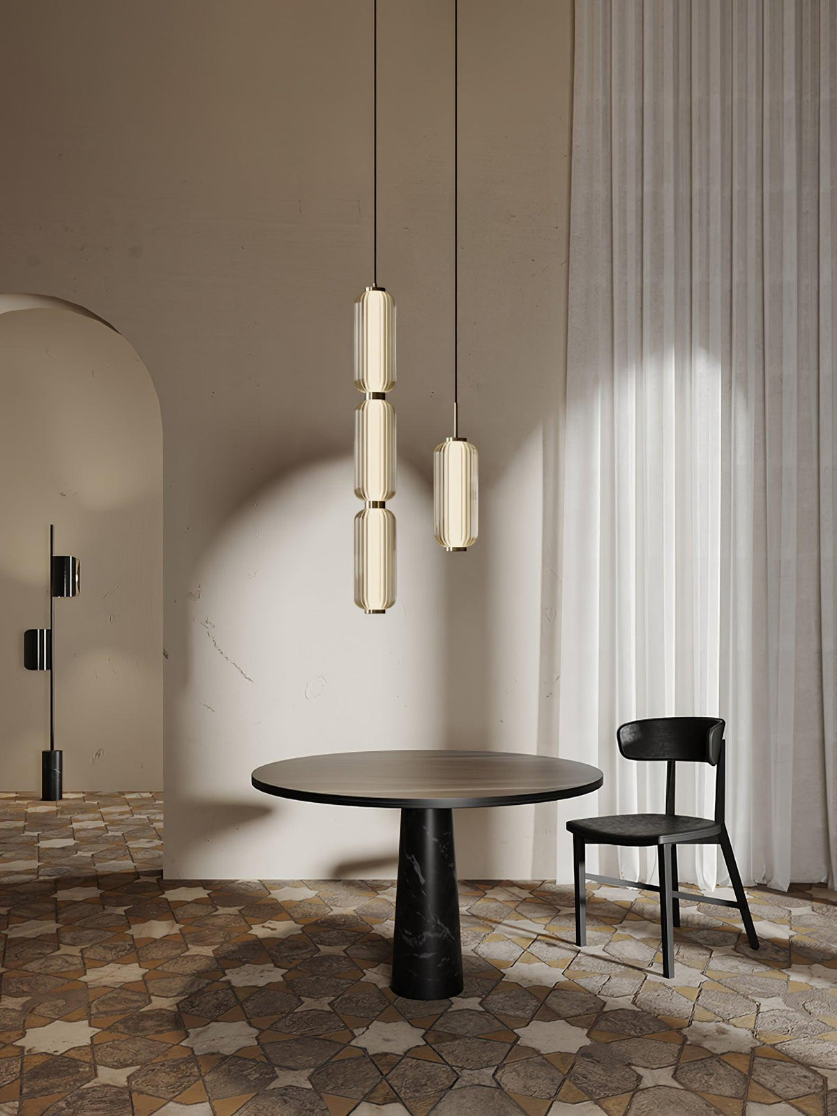 Two Clérachic ribbed glass pendants, a stacked one and a single, hang above a round table and black chair, beside a pale curtain.