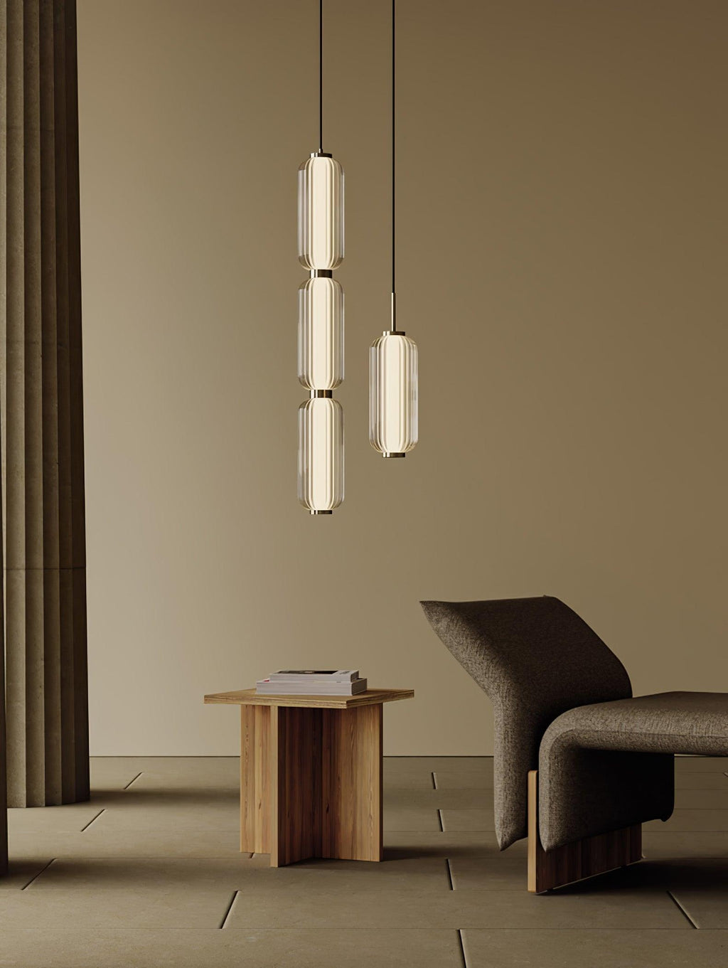 A stacked and a single ribbed glass Clérachic pendant glow in a beige room with a wooden side table and a dark lounge chair.