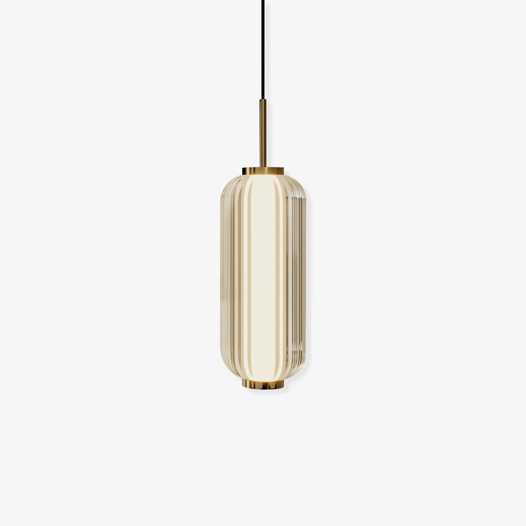 A ribbed glass cylinder Clérachic pendant with a gold stem and caps, in a champagne-tinted version on an off-white backdrop.