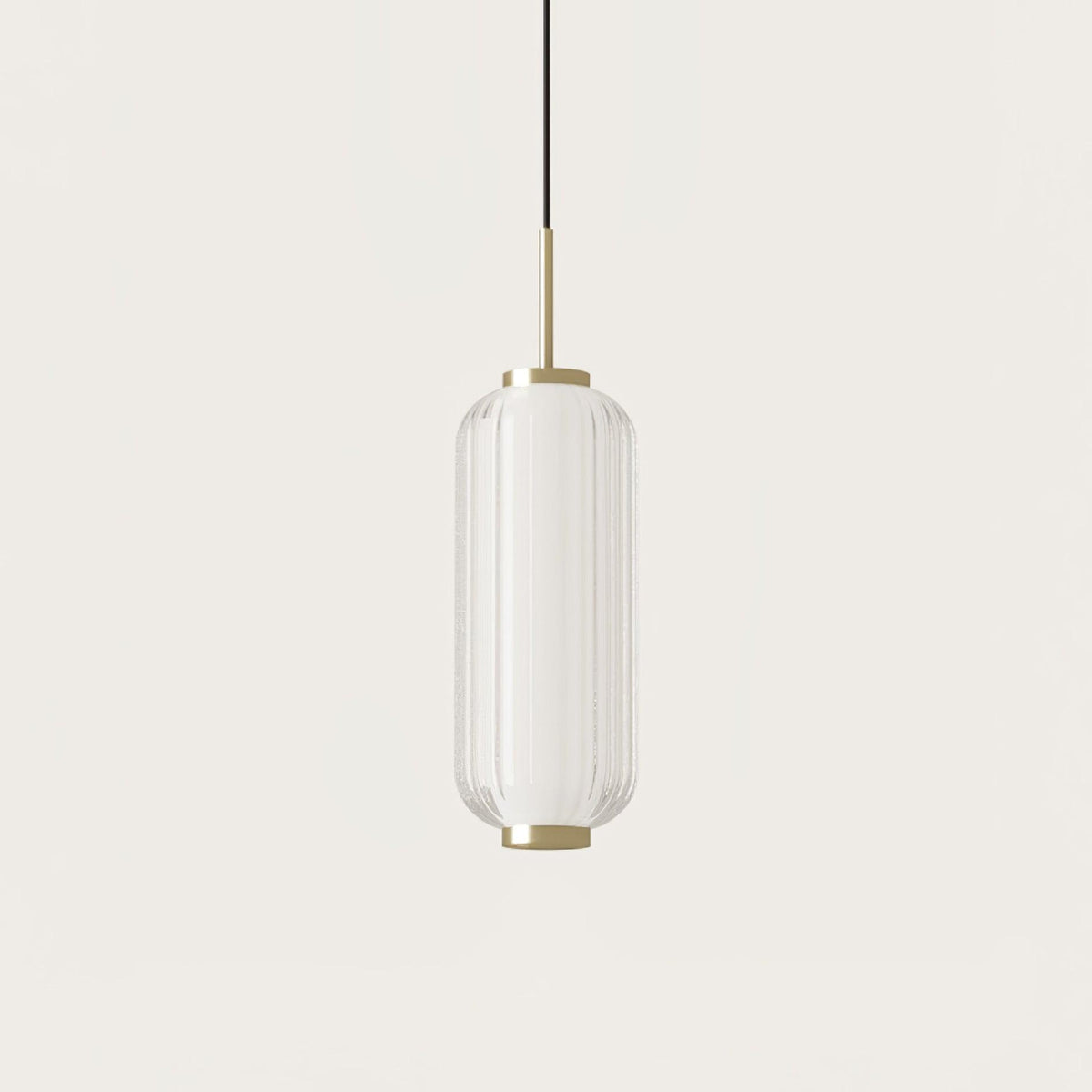 A ribbed clear glass Clérachic pendant with a gold stem, hanging on a plain warm-white backdrop.