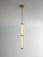 A two-tier ribbed glass Clérachic pendant on a gold canopy, lit warm along its inner tube against a pale wall.