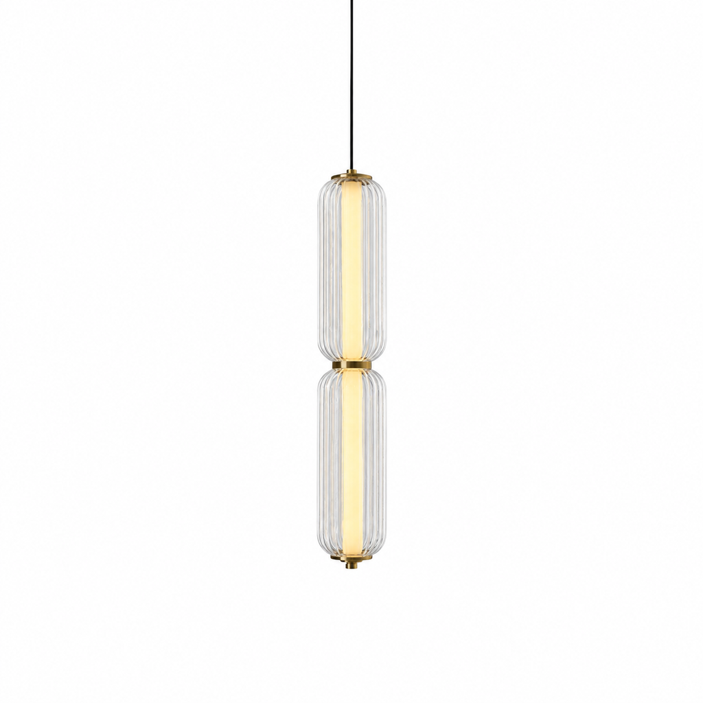 A slim two-tier Clérachic pendant in clear ribbed glass with a warm glowing inner tube and gold collars, on white.