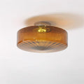 Clérachic Sunburst Amber Glass Flush Mount Ceiling Light lit on a plain white ceiling, casting a soft amber ring around the drum.
