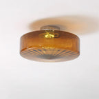 Clérachic Sunburst Amber Glass Flush Mount Ceiling Light lit on a plain white ceiling, casting a soft amber ring around the drum.