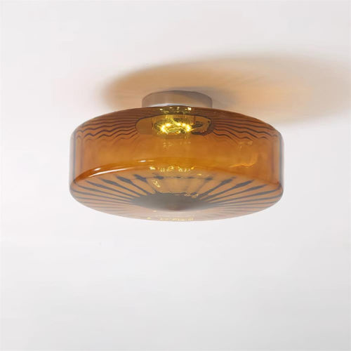 Clérachic Sunburst Amber Glass Flush Mount Ceiling Light lit on a plain white ceiling, casting a soft amber ring around the drum.