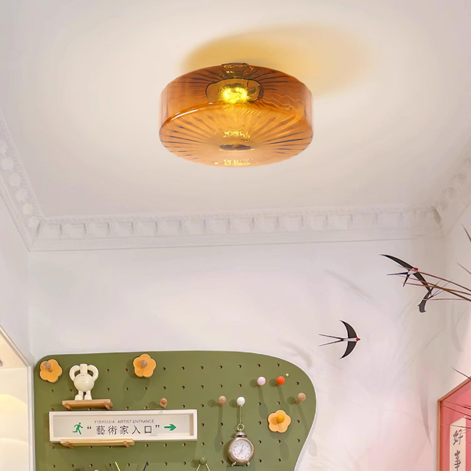 Clérachic Sunburst Amber Glass Flush Mount Ceiling Light lighting an entry hall above a green pegboard rack and cornice moulding.