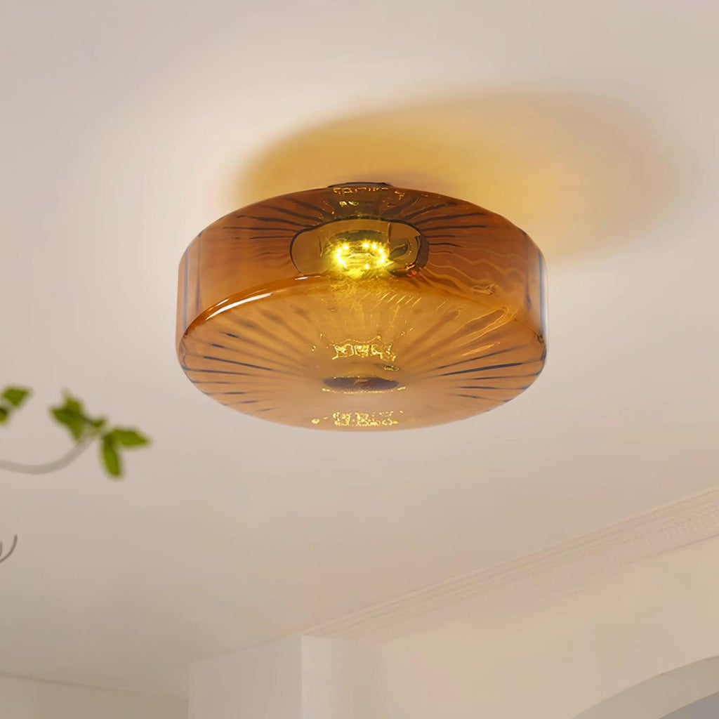 Clérachic Sunburst Amber Glass Flush Mount Ceiling Light throwing a soft halo onto the ceiling, with a trailing plant just in frame.