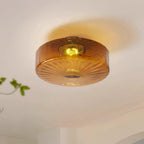 Clérachic Sunburst Amber Glass Flush Mount Ceiling Light throwing a soft halo onto the ceiling, with a trailing plant just in frame.