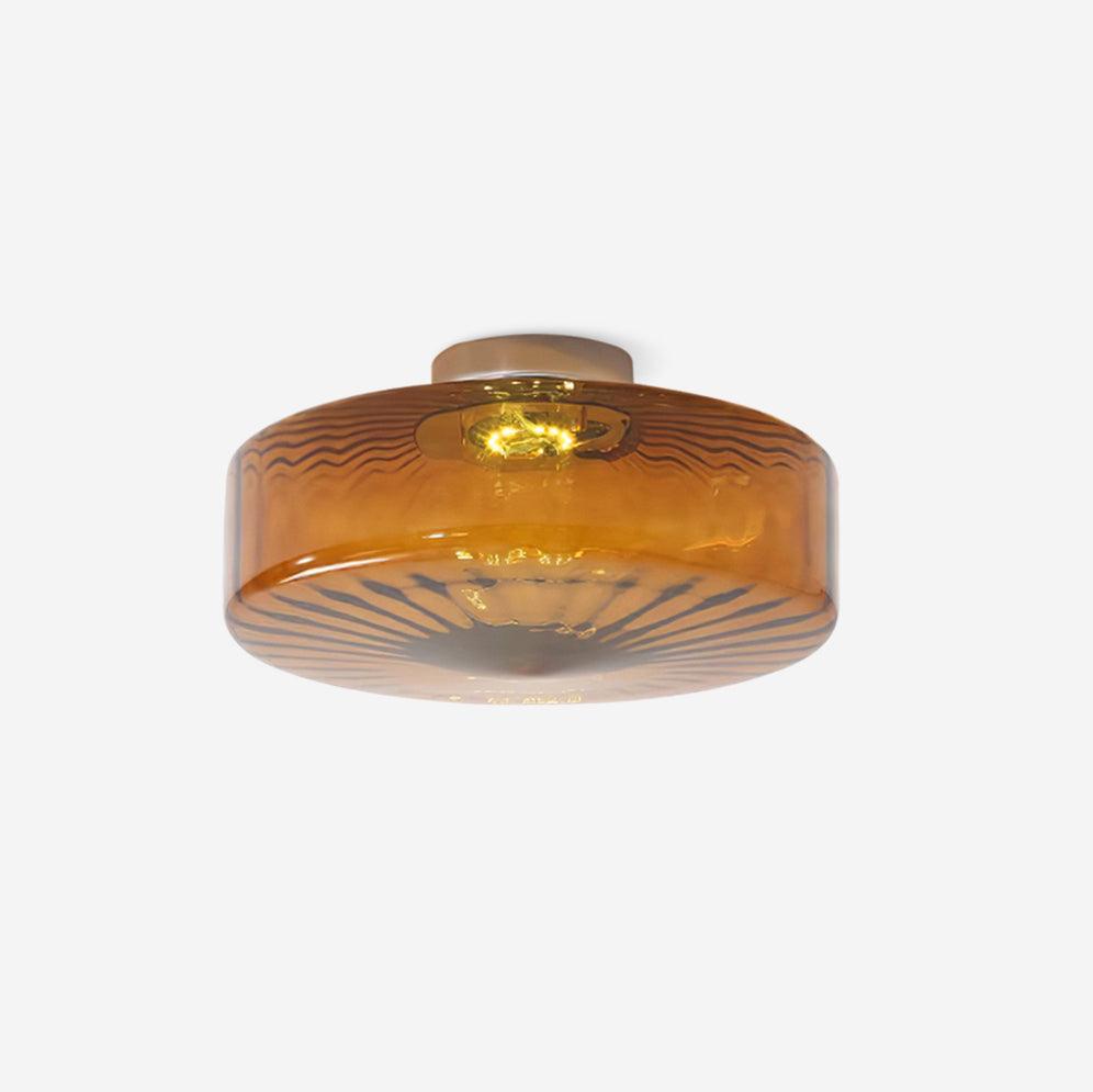 Product shot of the Clérachic Sunburst Amber Glass Flush Mount Ceiling Light on a plain background, ribbed drum lit warm from within.