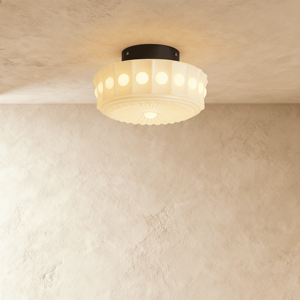 Clérachic flush ceiling light lit warm, a fluted opal glass shade with round bead windows and a sunburst base on a black plate.