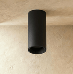 Clérachic surface downlight in matte black aluminium mounted flush on a plaster ceiling corner, shown unlit.