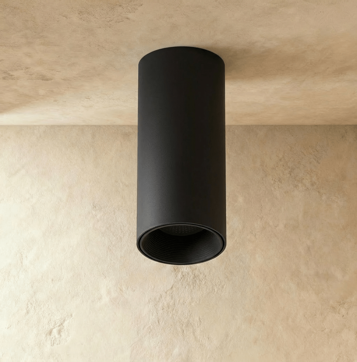 Clérachic surface downlight in matte black aluminium mounted flush on a plaster ceiling corner, shown unlit.