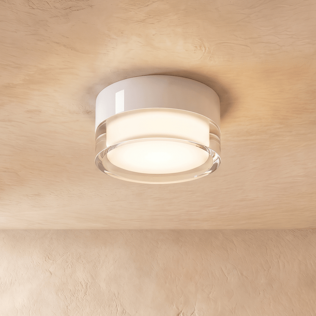 Clérachic white round flush ceiling light with a clear acrylic edge around a softly lit frosted centre, on a limewash ceiling.