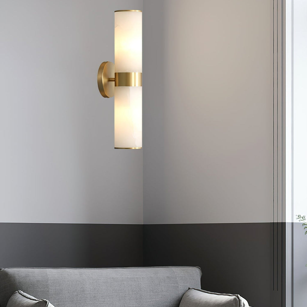 The Clérachic Sway on a corner wall above a grey sofa, its brass stem catching the daylight.