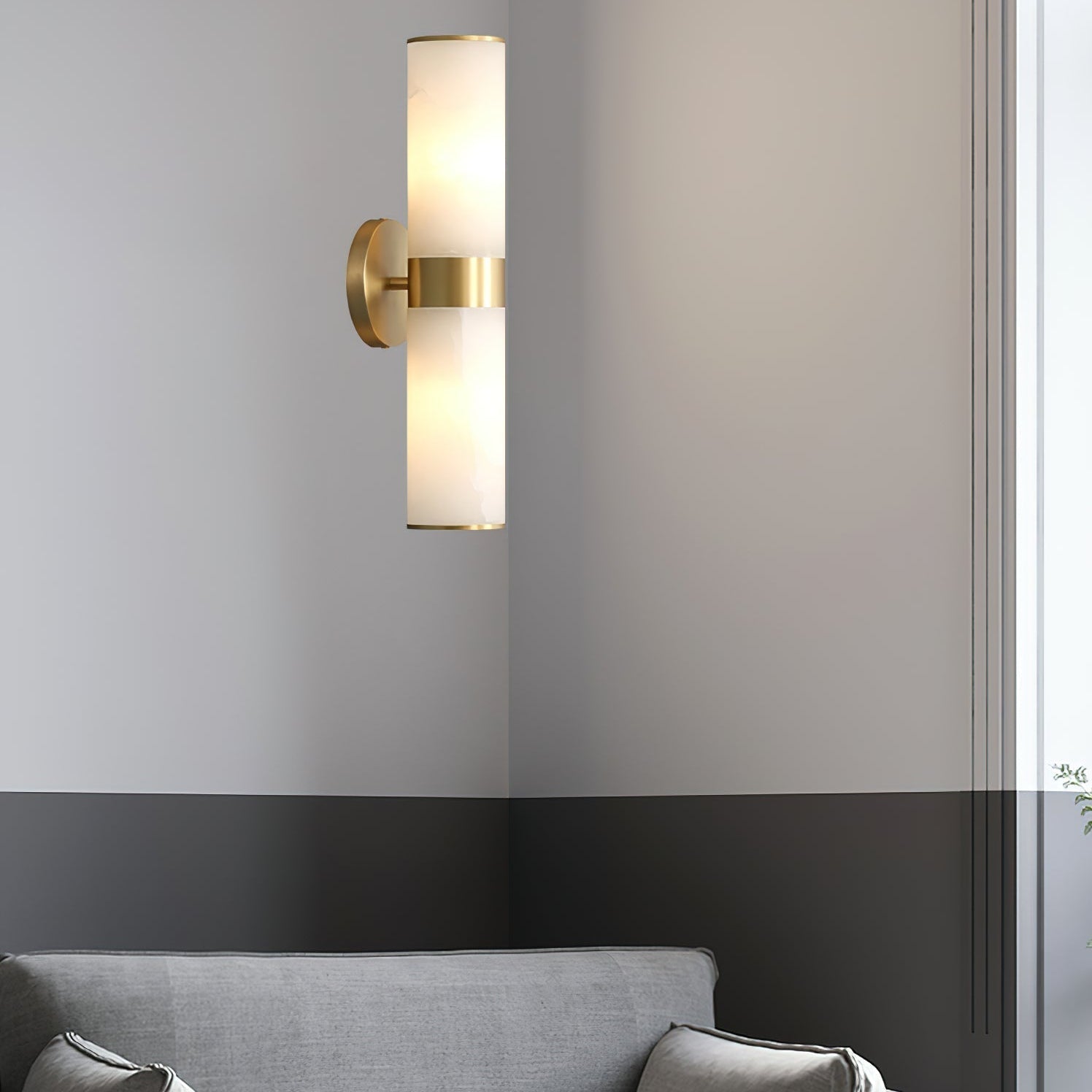 The Clérachic Sway on a corner wall above a grey sofa, its brass stem catching the daylight.