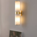 Clérachic Sway close up, warm light pooling on the wall above and below the brushed brass centre band.