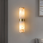 The Clérachic Sway alight on a grey wall, golden veining vivid in the stone beside a framed print.