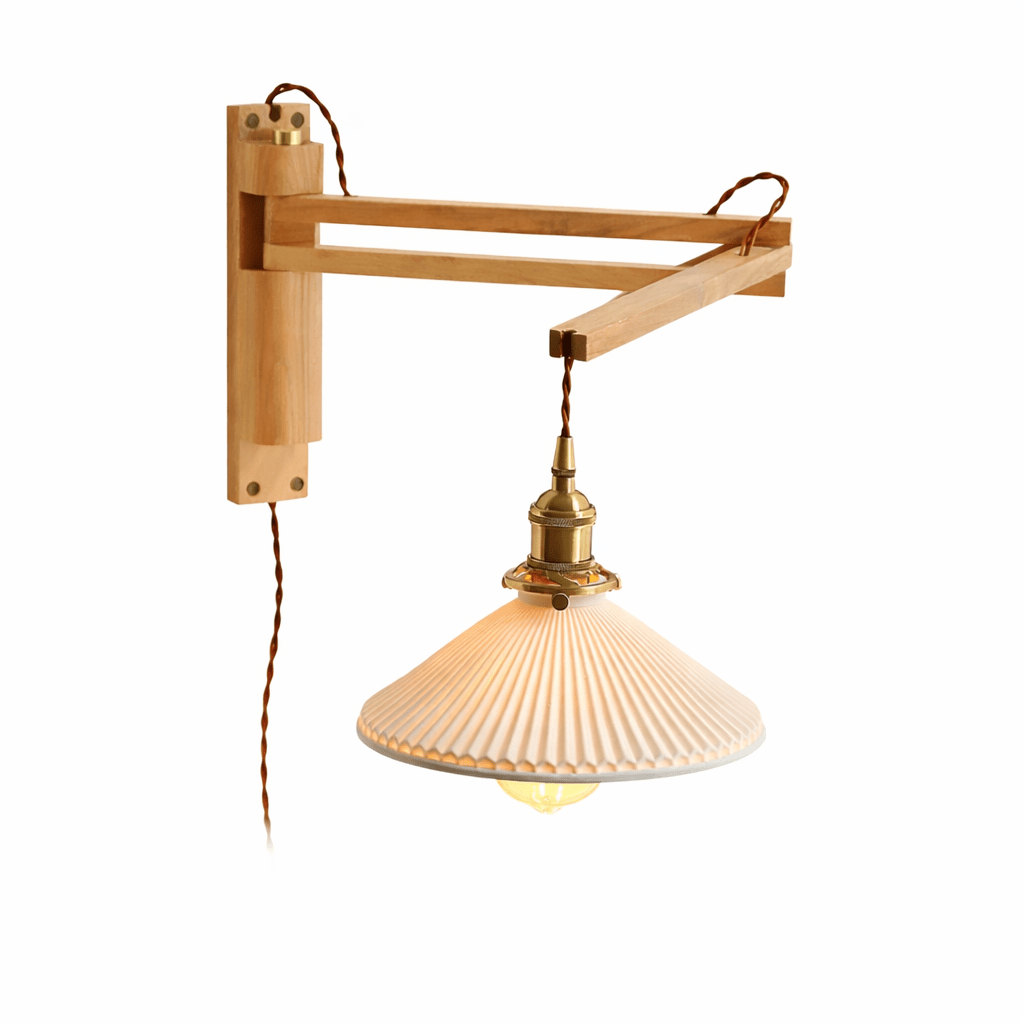 A pale light-wood swing arm on this Clérachic wall light, shown on a white backdrop with its pleated shade and twisted flex.