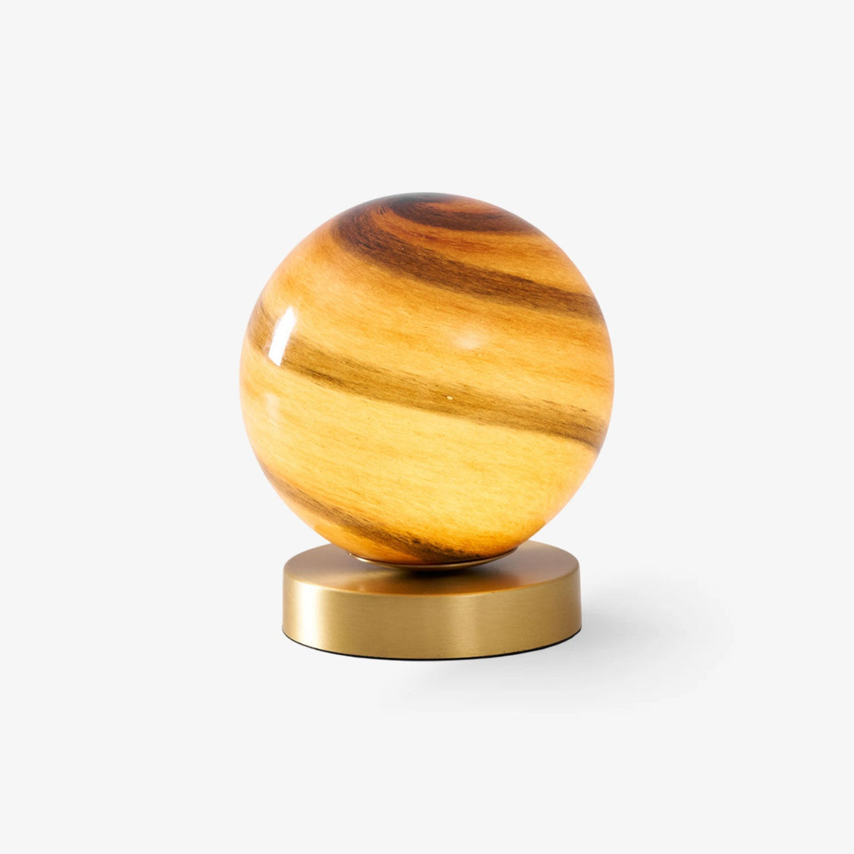 This Clérachic table lamp on a plain white backdrop, a banded amber glass sphere resting on a round brass base.