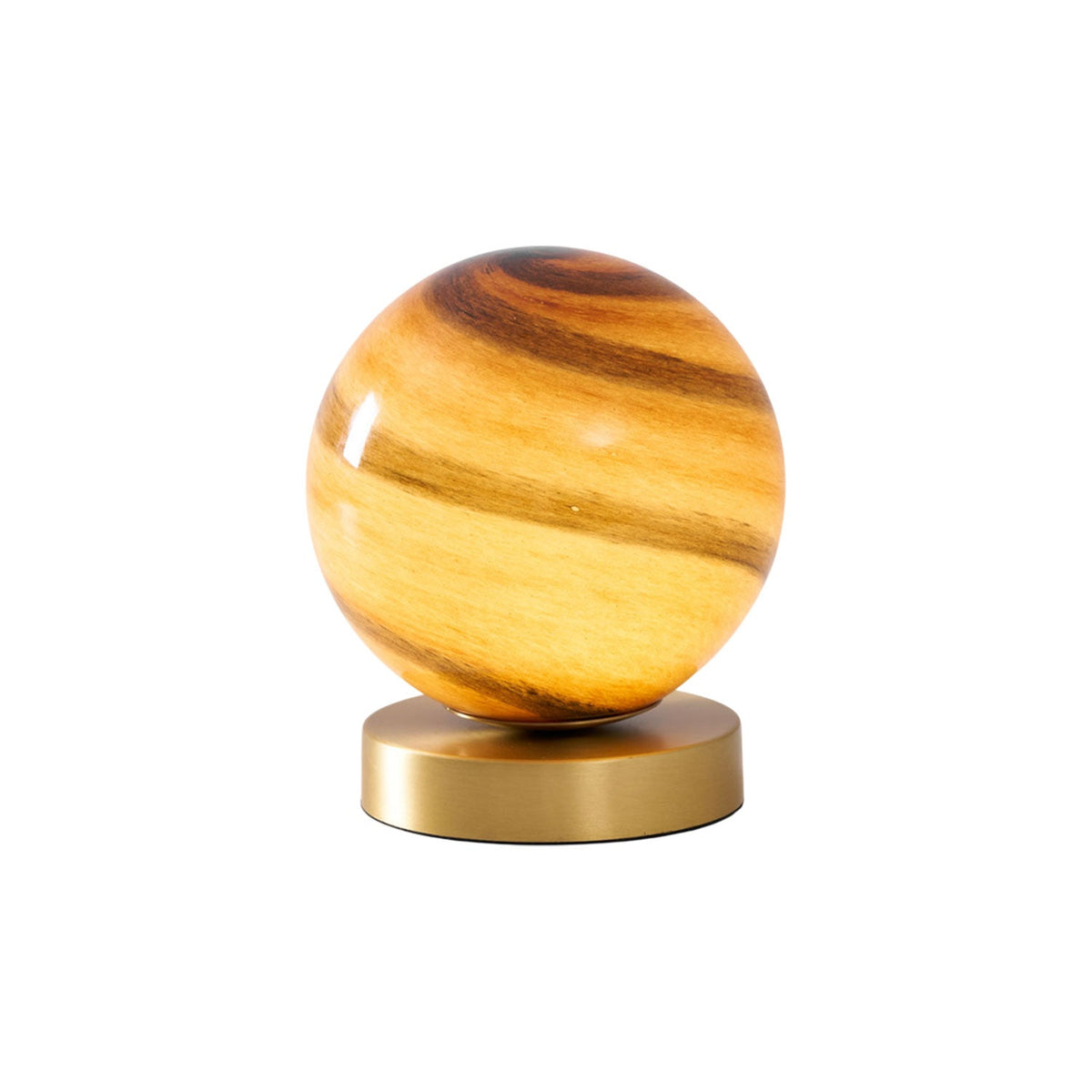 Lit Clérachic table lamp on white, a swirled amber glass globe above a round brass base with a soft glow.