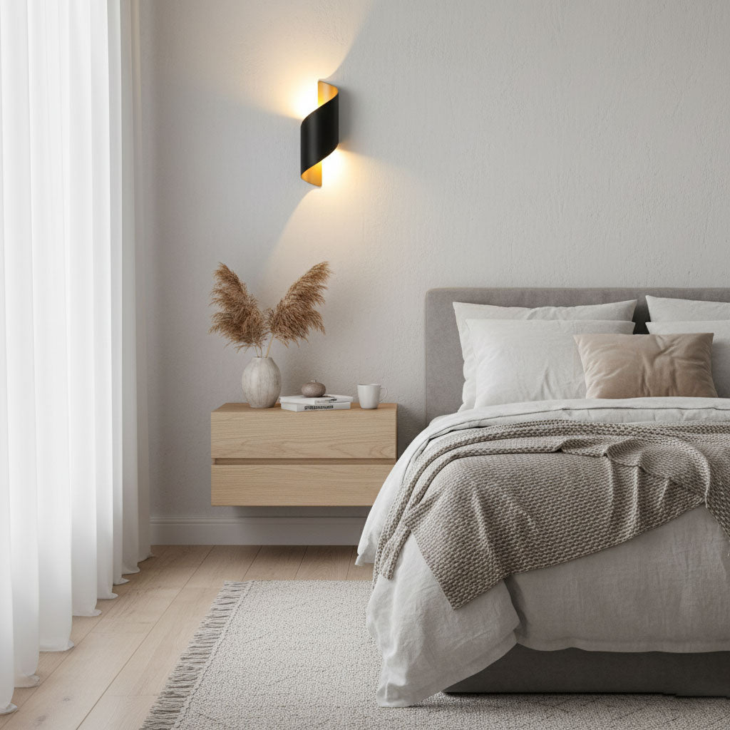 Black Clérachic wall light with a gold-toned inside above a floating bedside shelf and a bed with a beige throw.