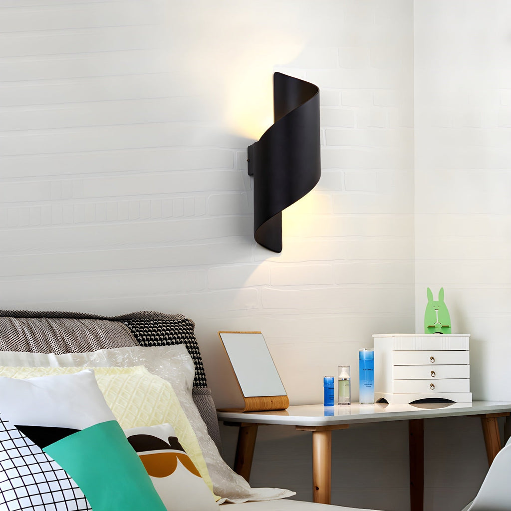 Unlit black Clérachic spiral wall light on white brick above a bedside table with a mirror and a small chest of drawers.