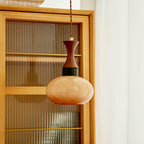 Clérachic Swirled Amber Glass Pendant Light in its small unlit shade, a soft caramel against a fluted cabinet in daylight.