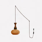 The small Clérachic amber glass pendant shown with its long twisted fabric cord, ceiling hooks, inline switch and wall plug.