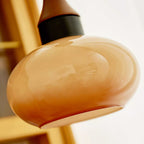 Close view of a Clérachic amber glass pendant shade, cloudy swirls running through the blown glass under a matte black collar.