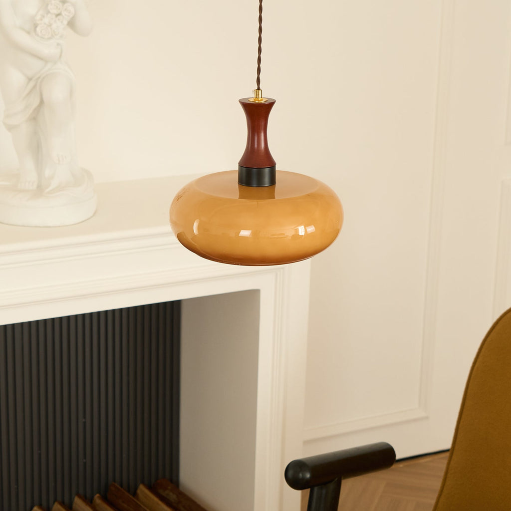 Clérachic Swirled Amber Glass Pendant Light hung beside a white mantel and panelled wall in a herringbone-floored room.