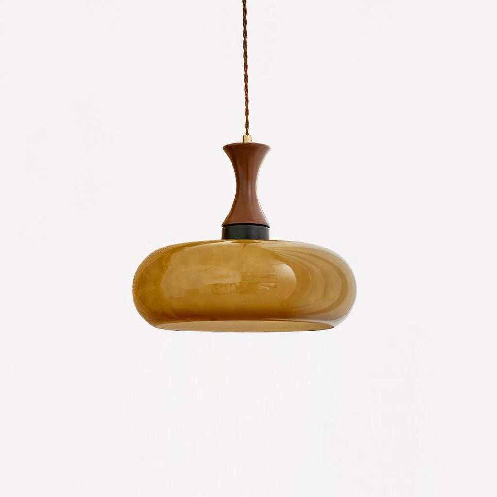 Studio shot of the wide Clérachic amber glass pendant shade, a low rounded drum of blown glass on a turned walnut neck.