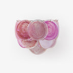 Pink glass-disc wall light from Clérachic on a plain white backdrop, its overlapping swirled discs in magenta and pale blush.