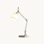 Silver swivel-arm table lamp from Clérachic with a white fabric shade, shown lit on a plain off-white backdrop.