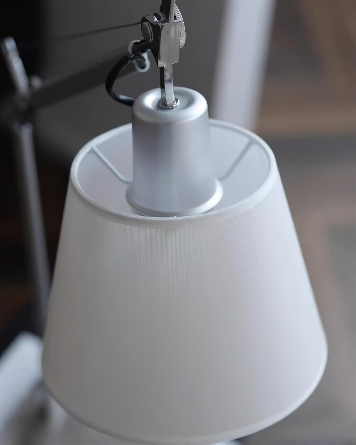 Looking down into the white fabric shade of this Clérachic lamp, where a silver metal cap holds the cord and holder.