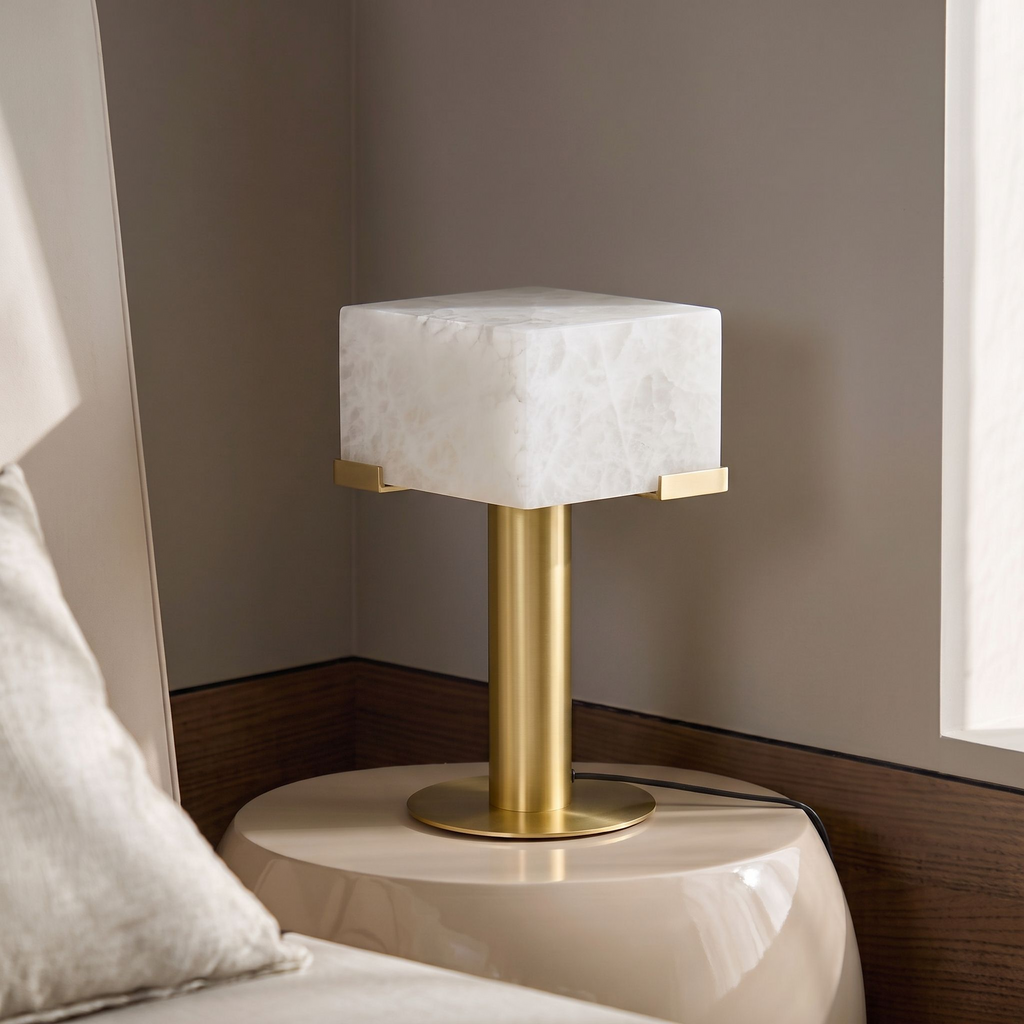 This Clérachic table lamp in brass sits on a glossy cream nightstand against a dark walnut headboard wall.