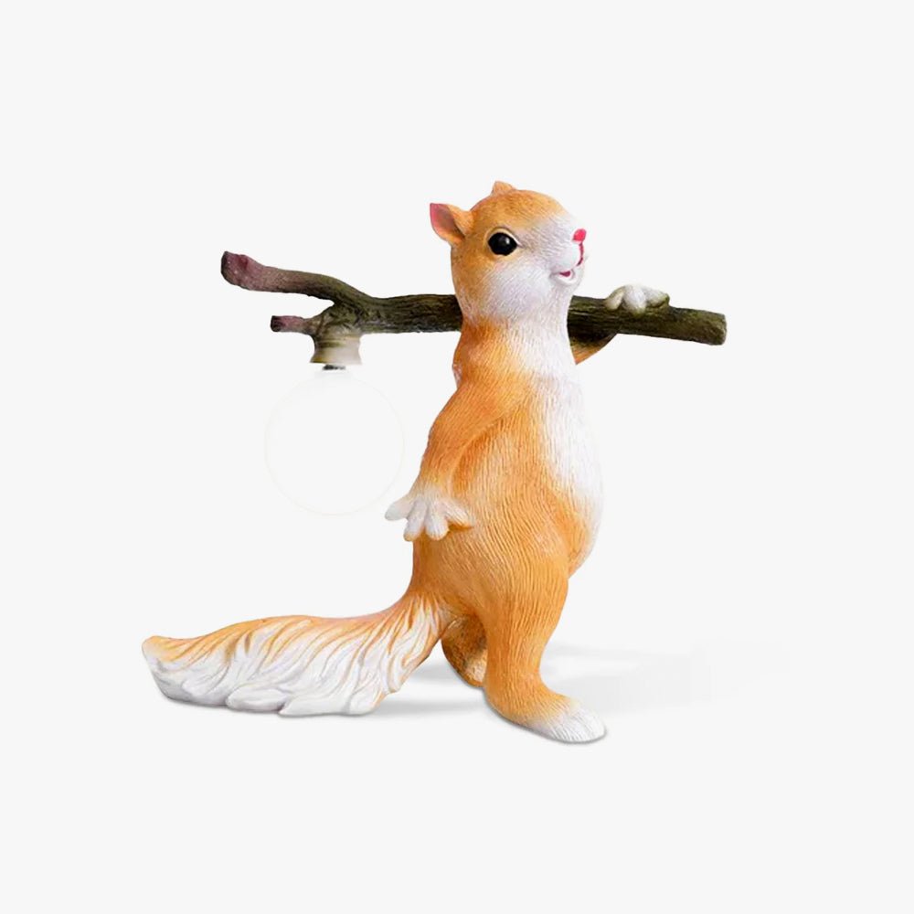 Clérachic table lamp, a cast resin squirrel in orange and white carrying a branch with a round glass bulb hanging from it, on white.