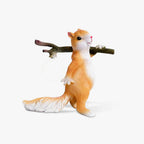 Clérachic table lamp, a cast resin squirrel in orange and white carrying a branch with a round glass bulb hanging from it, on white.