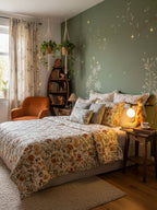 A Clérachic squirrel lamp glowing on a bedside table next to a bed with floral bedding, under a sage wall with gold dots.