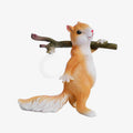 Orange and white Clérachic squirrel lamp with its round bulb off, standing on a white backdrop with the branch over its shoulder.