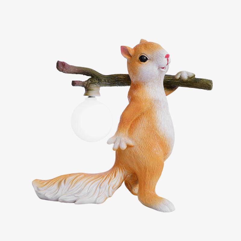 Orange and white Clérachic squirrel lamp with its round bulb off, standing on a white backdrop with the branch over its shoulder.