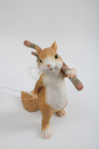 Clérachic squirrel lamp on a pale grey backdrop, shown from the front with the branch angled over its shoulder.