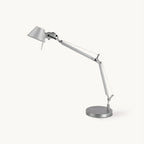 This Clérachic chrome desk lamp on a plain white backdrop, with a jointed arm, a conical shade and a round base.