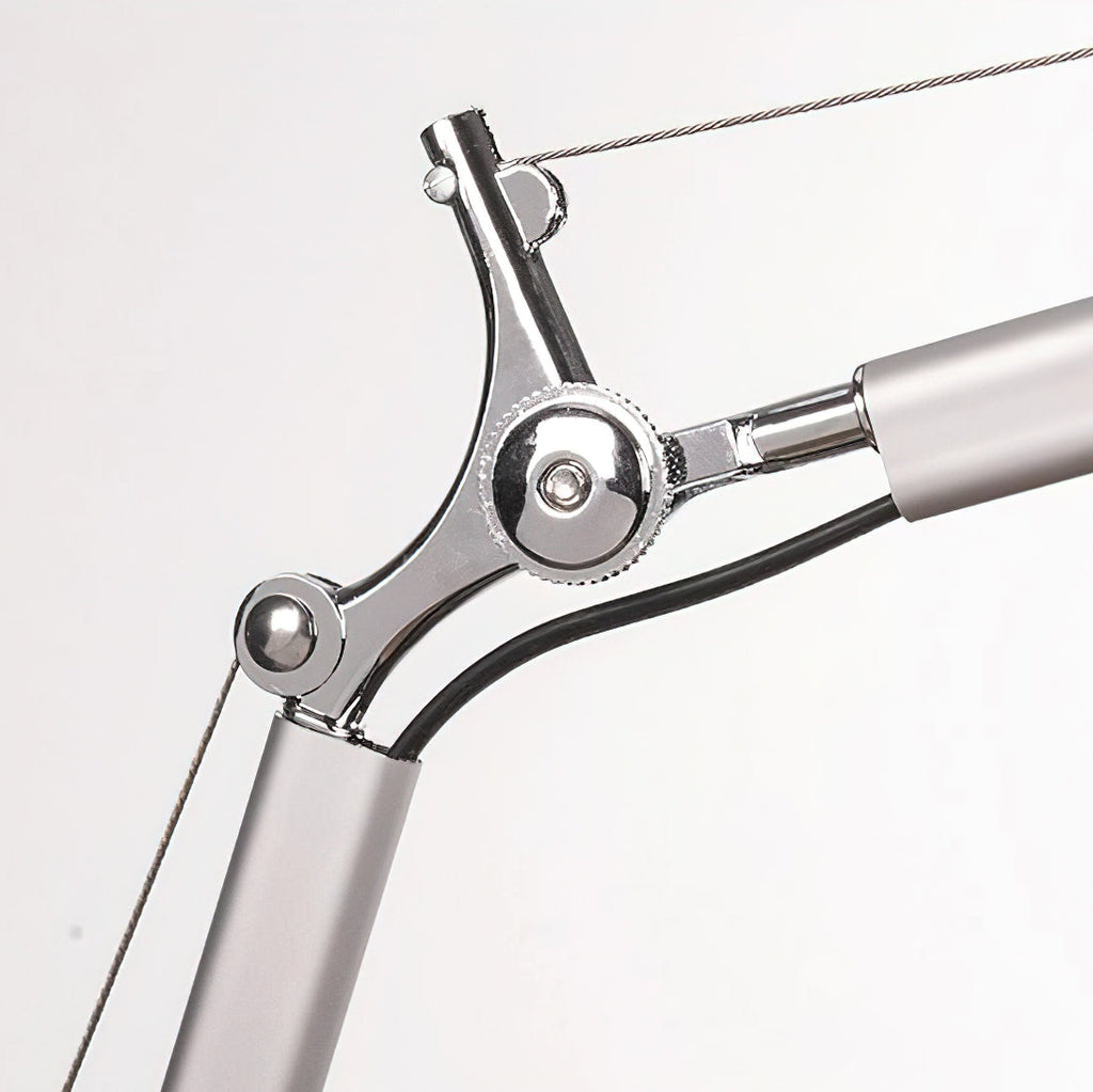 Close view of the arm joint on this Clérachic desk lamp, showing the chrome pivot, the black cable and the support wire.