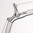 Close view of the arm joint on this Clérachic desk lamp, showing the chrome pivot, the black cable and the support wire.