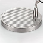 Close view of the round chrome base of this Clérachic desk lamp, with its ridged top and a slim central stem.