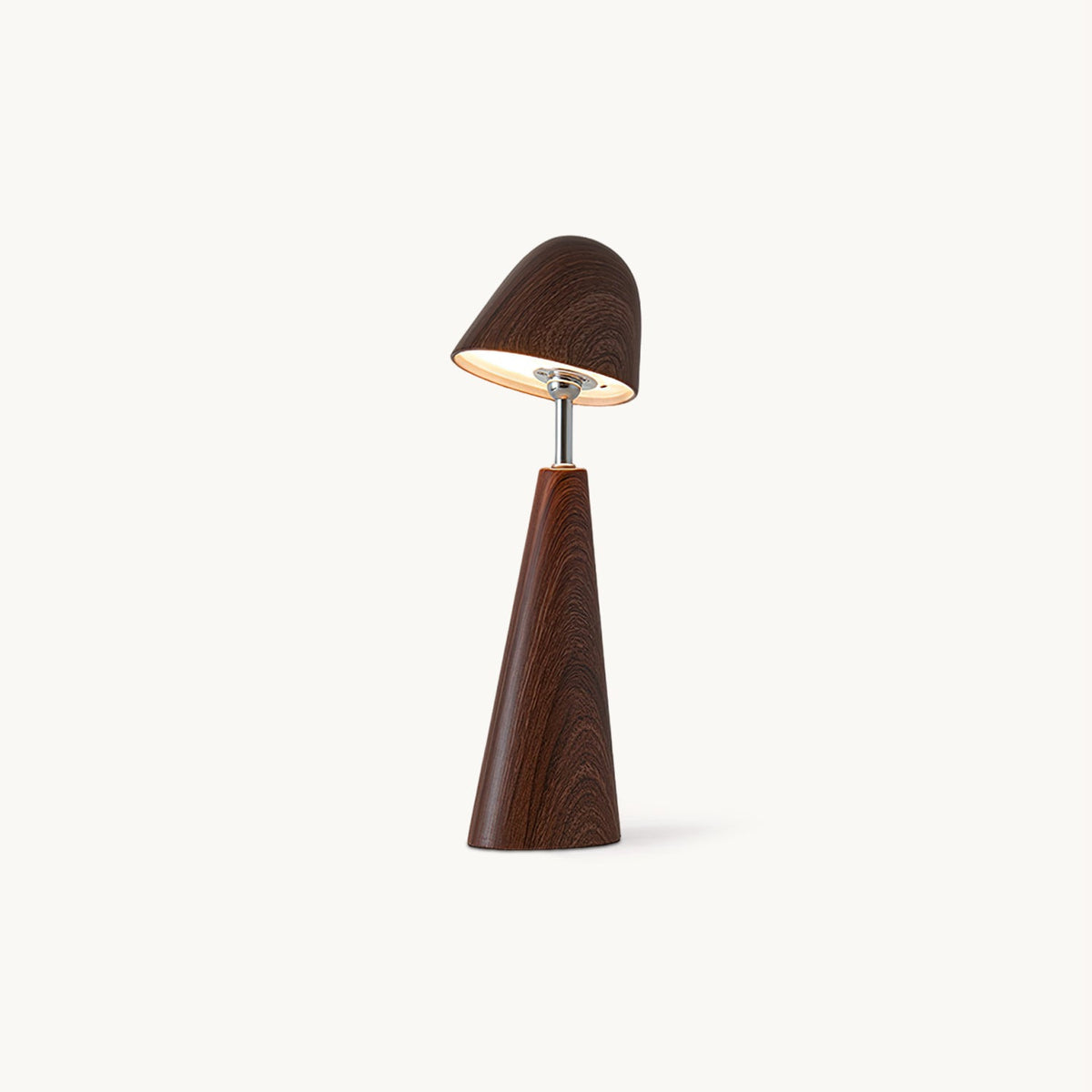 Walnut-finish Clérachic table lamp with a tilted dome shade on a slim metal stem and a tapered wood-grain base, lit on a plain backdrop.